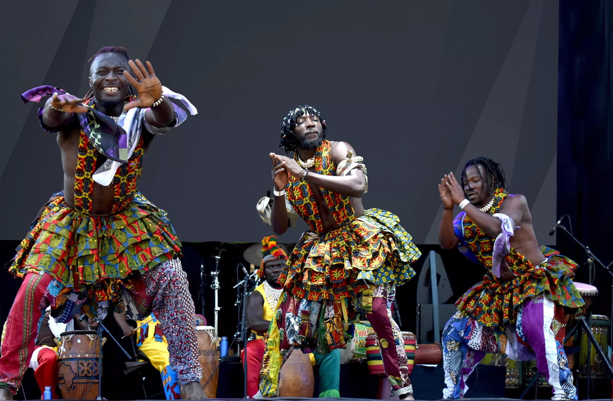 Groupe d'artistes exécutant une danse traditionnelle en costumes colorés, symbole de l'énergie culturelle francophone